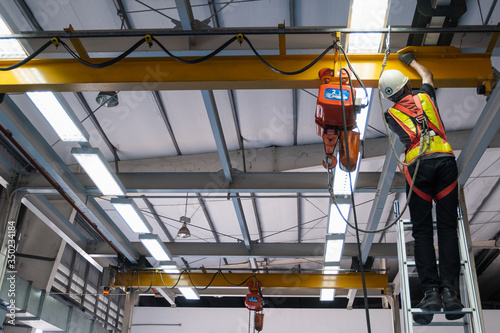 Engineers are inspecting hooks for lifting safety crane steel In the factory auto parts license Crane Operation