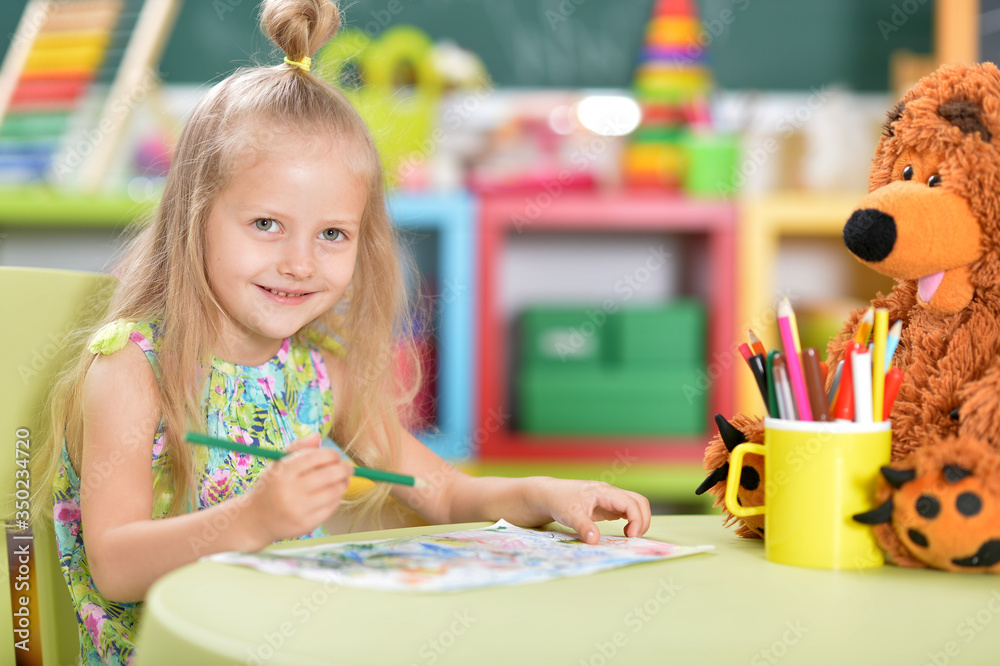 Fototapeta premium Cute beautiful little girl drawing at table