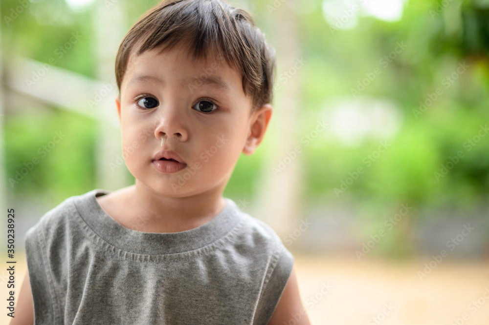 Closeup the boy is cold and has runny nose,Close up Mucus flowing from nose of little Asian boy. child has a runny nose with clear snot,virus isolated Closeup the boy is cold and has runny nose,Close up Mucus flowing from nose of little Asian boy. child has a runny nose with clear snot,virus isolated