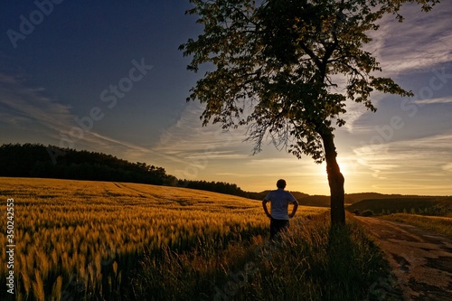 A middle-aged man takes in the beauty of a glorious sunset in Germany while taking exercise during the Corona crisis.