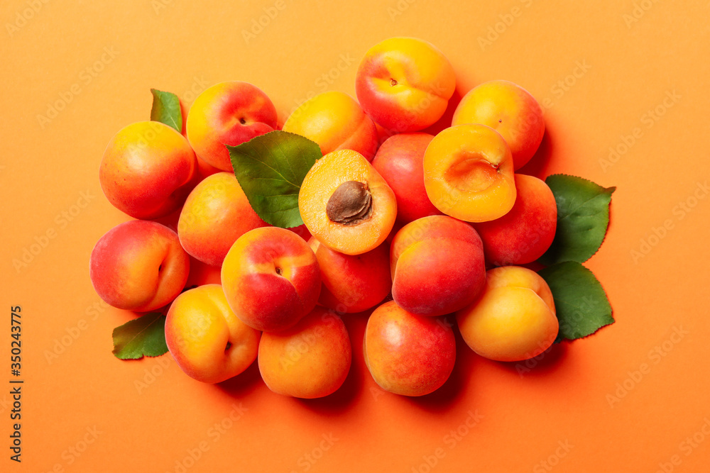 Fresh tasty apricots on orange background, top view