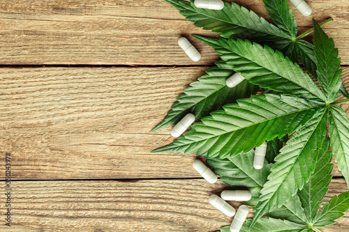 Cannabis Sativa Leaves On Dark.Assorted cannabis products, pills and cbd oil - medical marijuana concept,alternative herb medicine.