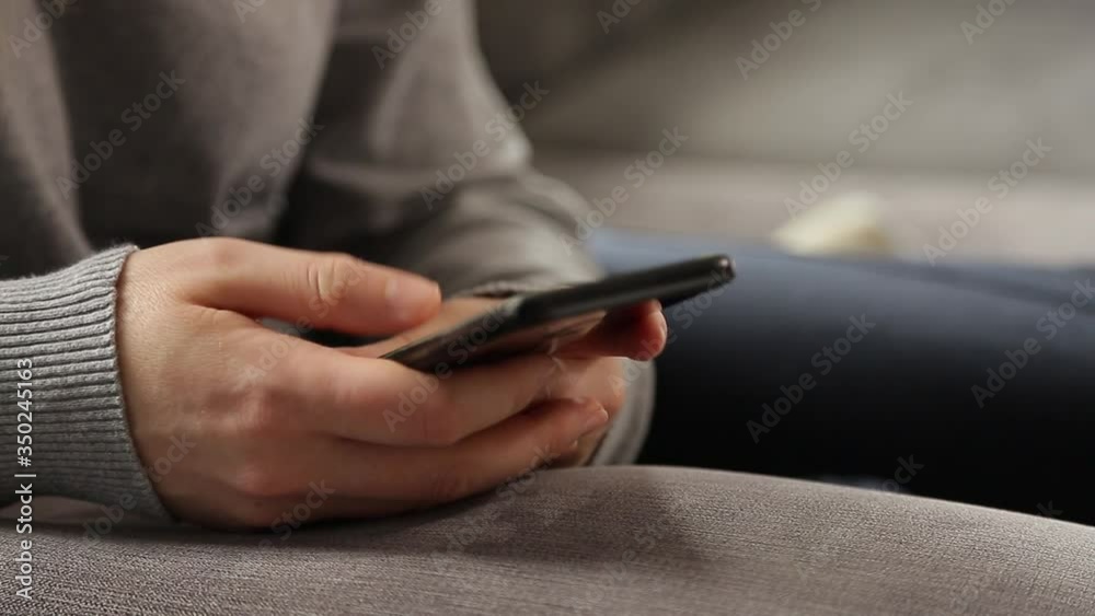Close up 4k video of a young woman using a smartphone at home. Close up 4k video of a young woman using a smartphone at home.