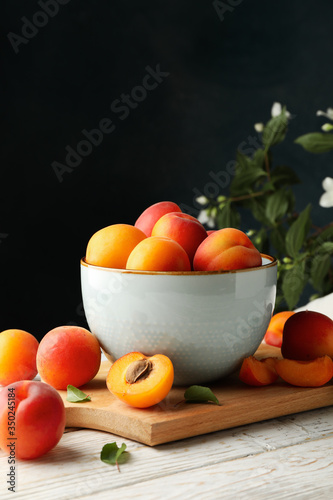 Fototapeta Naklejka Na Ścianę i Meble -  Composition with tasty apricots on wooden table against dark background