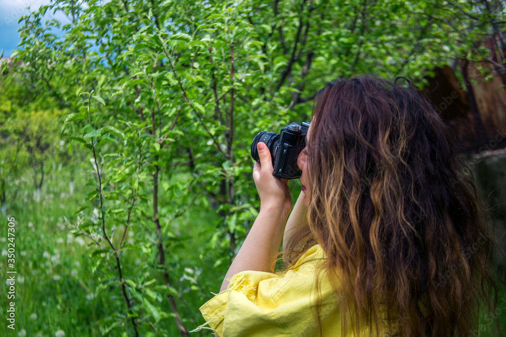woman take photo with old film camera in nature