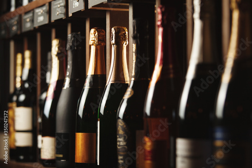 Slika na platnu Underground cellar with elite sparkling wine on shelves, close up horizontal photo