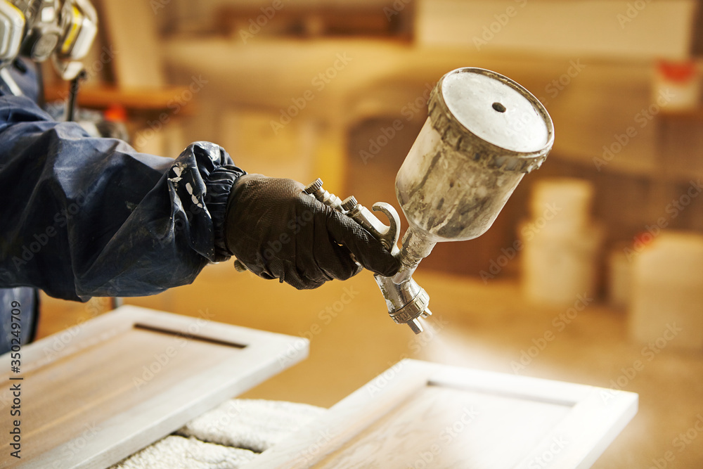 Staining wood with white spray gun. Application of flame retardant ensuring  fire protection, airless spraying device. Photos | Adobe Stock