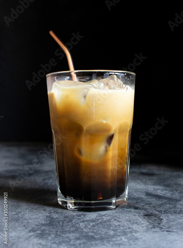 Wallpaper Mural Coffee with milk and ice in a tumbler glass cup with a metal straw on a dark background Torontodigital.ca