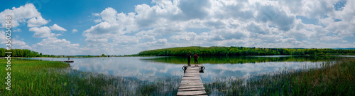 fishing pole with beautiful lake, mountains, forest and steel sky background. Fishing tool and sport concept