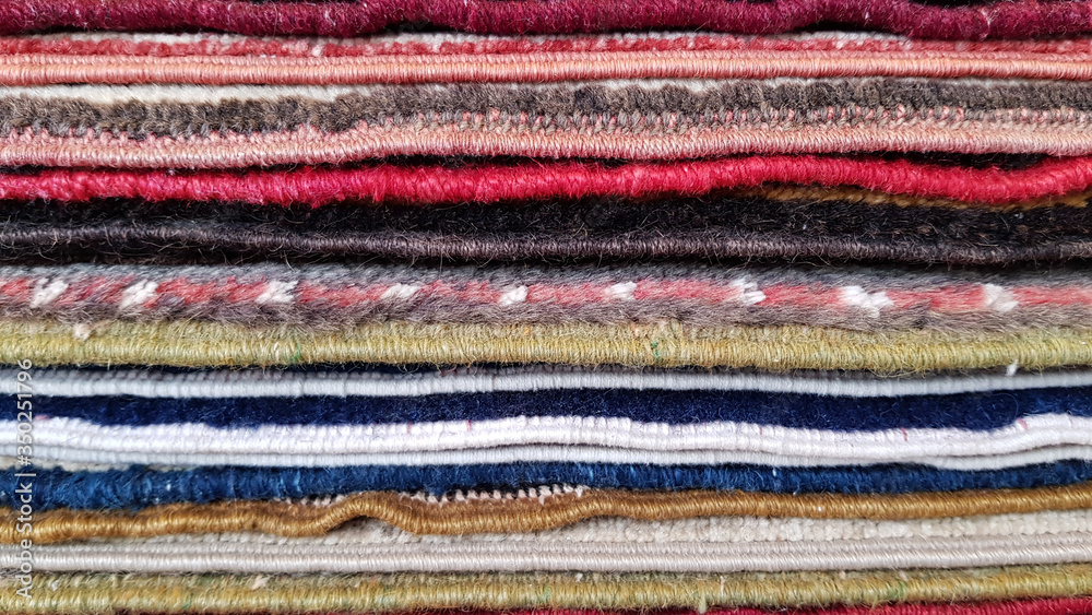 colorful wool fabric texture. Closeup of folded rugs texture. Striped pattern background colorful wool fabric texture. Closeup of folded rugs texture. Striped pattern background