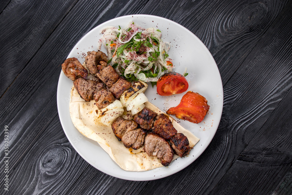 grilled meat on pita bread with salad on a black wooden background grilled meat on pita bread with salad on a black wooden background