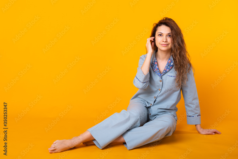 Young girl posing in pajamas on yellow background. Relax good mood, lifestyle and sleepwear concept. Young girl posing in pajamas on yellow background. Relax good mood, lifestyle and sleepwear concept.