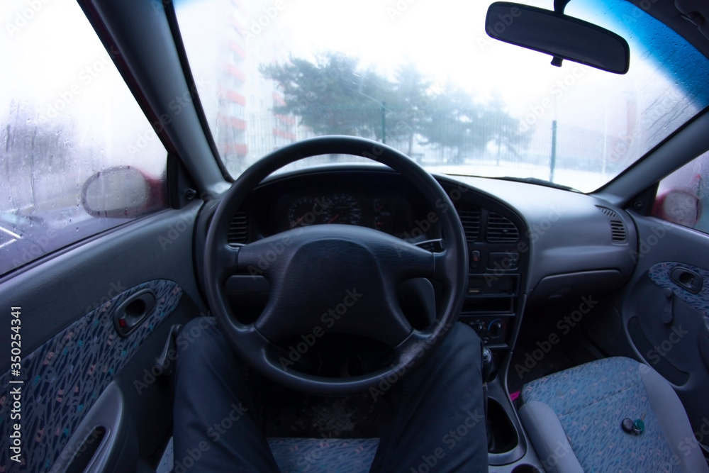 Man is sitting in a car in the early morning