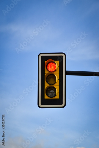 traffic light with sky background with clouds, in red phase