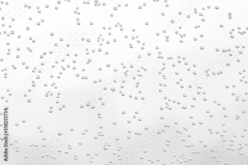 Soda sparkling drink little bubbles with glass transparent white surface background macro