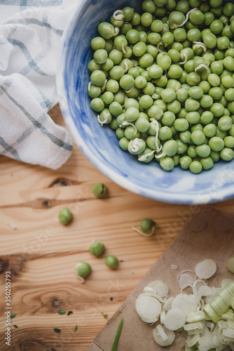 Bol de petits pois crus sur une table en bois photo