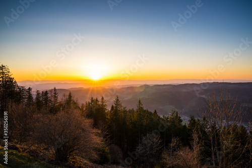 Germany  Romantic orange sunset sky with sunrays over vosges mountains nature landscape view from hoernleberg mountain at dawn