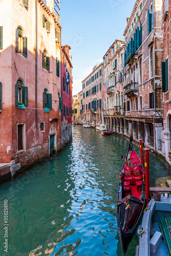 Canal and its facades and gondolas in Venice in Veneto, Italy