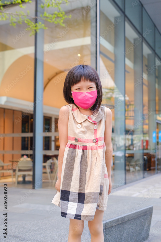 Asian child wearing mask in city street