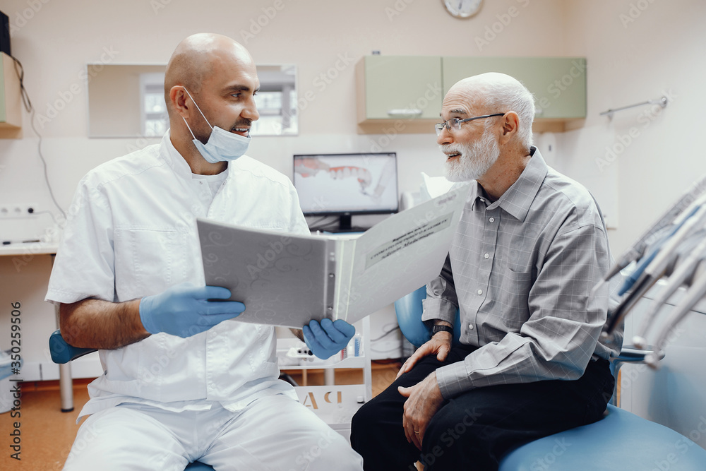 Handsome old man talking to the dendist. Two men in the dentist's office Handsome old man talking to the dendist. Two men in the dentist's office