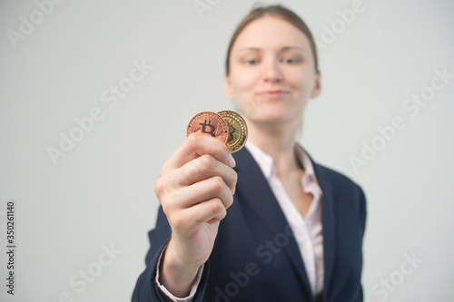 Business woman holding a physical bitcoin cryptocurrency in her hand