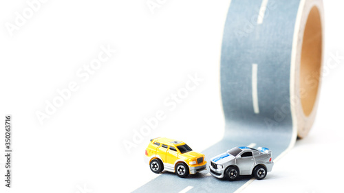 Cars accident on rough road. Two toy models on duct tape. Slippery or rough road.