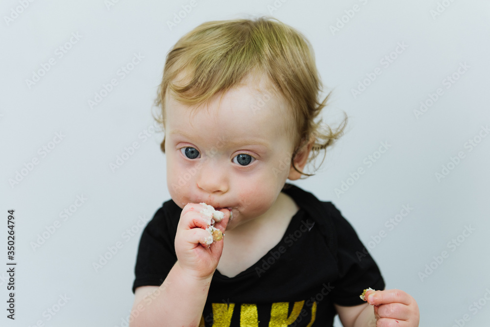 Toddler tries a cake on her first birthday. The first birthday of the baby. Toddler tries a cake on her first birthday. The first birthday of the baby.