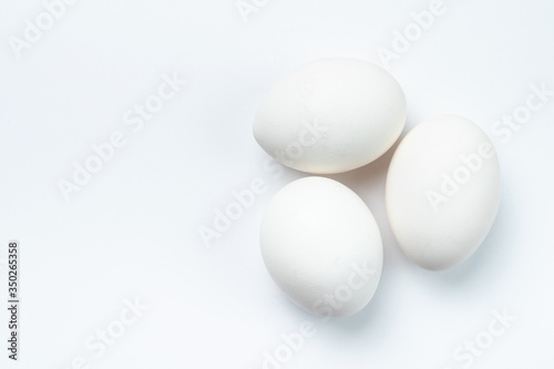 Three white chicken eggs isolated on white background