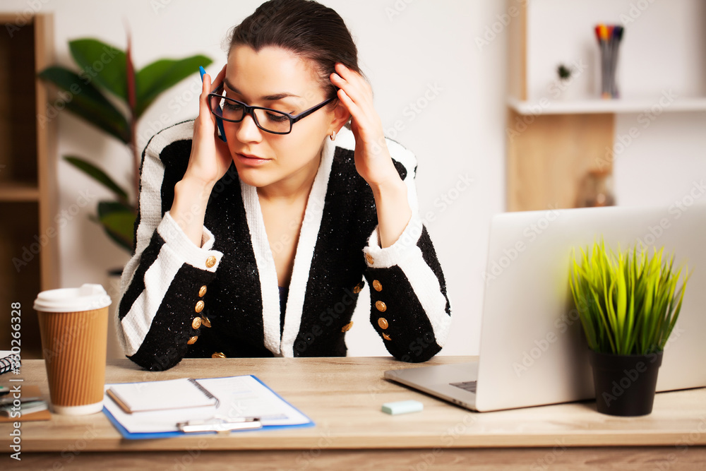 Attractive business woman working on laptop in her workstation. Attractive business woman working on laptop in her workstation.
