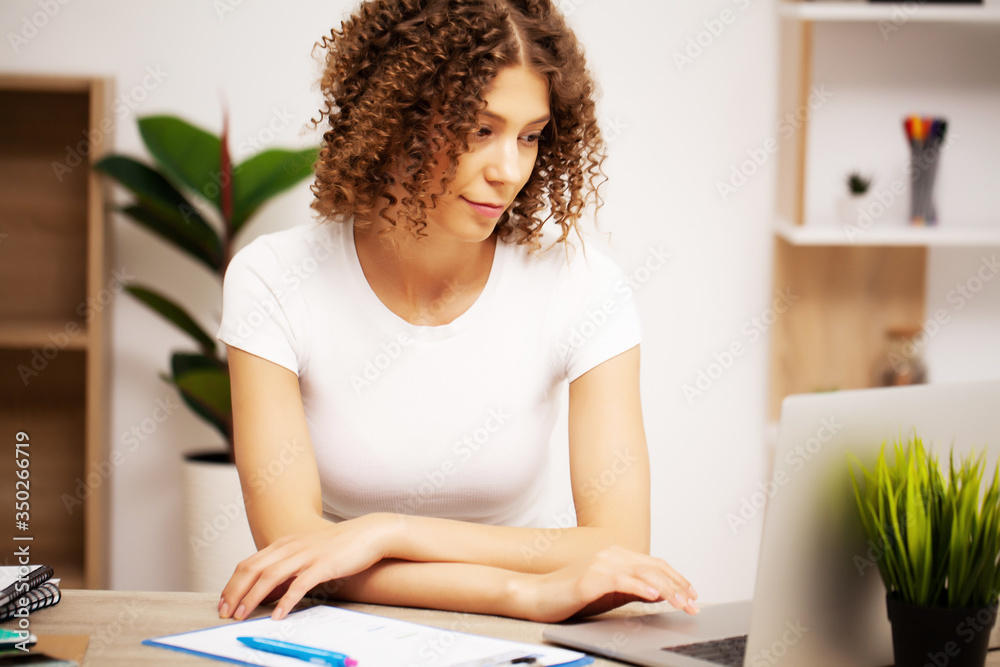 Attractive business woman working on laptop in her workstation. Attractive business woman working on laptop in her workstation.