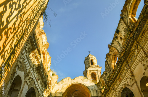 Glimpse of the ruins of the Church of Sant'Egidio, whose bell tower has miraculously escaped the earthquake of 1878 that caused the abandonment of the medieval village, Bussana Vecchia, Imperia, Italy