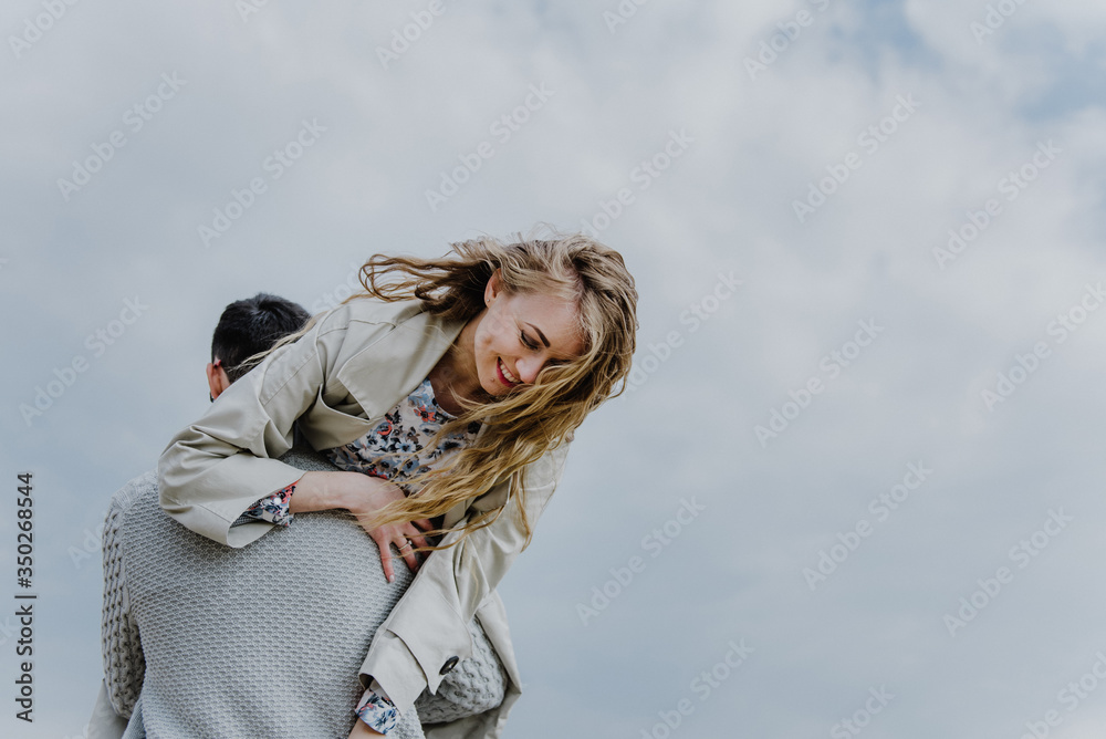 A man holds a woman on his shoulders, she laughs. A man holds a woman on his shoulders, she laughs.