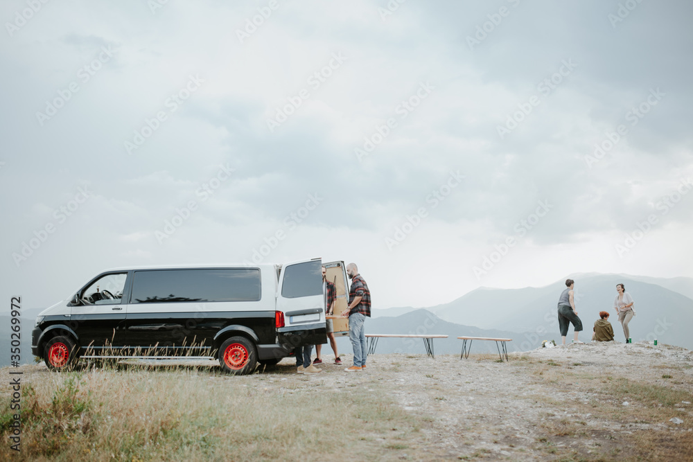Group of friends camping on mountain top. Fun picnic in the mountains. Group of friends camping on mountain top. Fun picnic in the mountains.