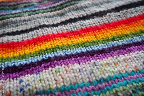 hand knitting in rainbow stripes background 
