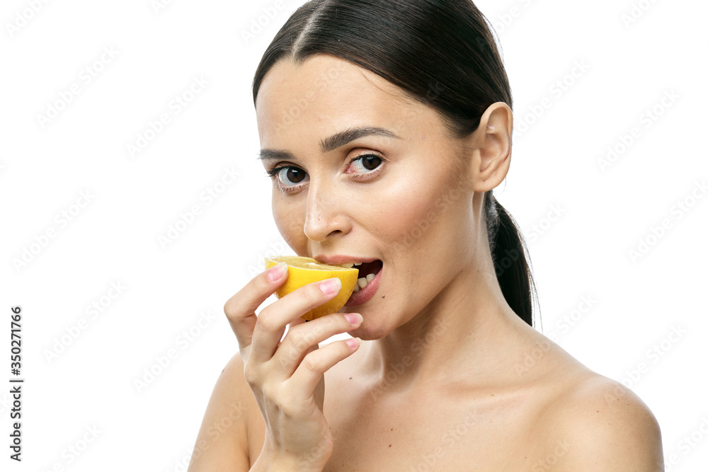 close-up portrait of a girl with clear skin holding a lemon fruit to her face, isolated on a white background close-up portrait of a girl with clear skin holding a lemon fruit to her face, isolated on a white background
