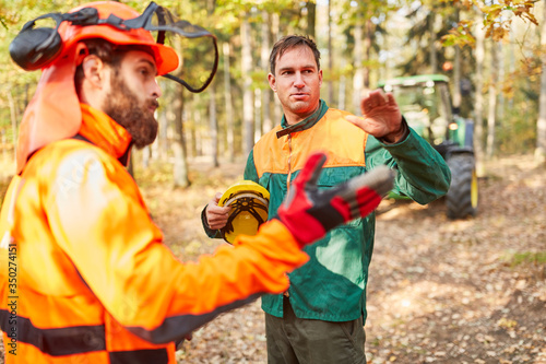 Zwei Waldarbeiter besprechen die Holzernte