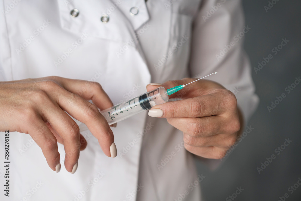 syringe in the hands of a nurse in a white coat syringe in the hands of a nurse in a white coat