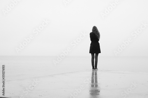 Konstfotografi A lonely girl looks out into the distance in the rain