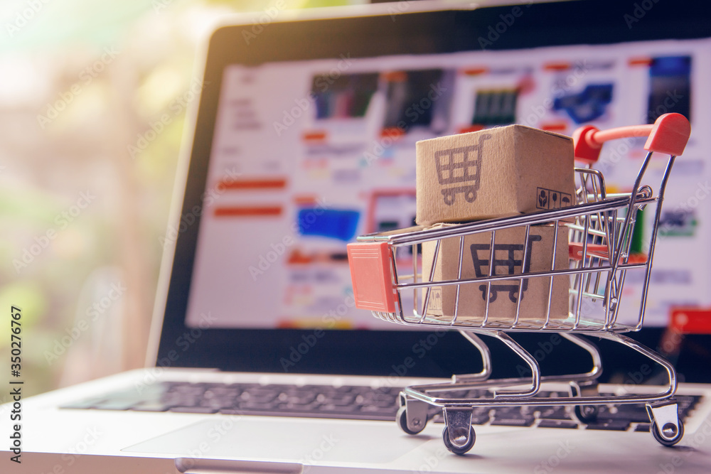 Shopping online. cardboard box with a shopping cart logo in a trolley on laptop keyboard. Shopping service on The online web. offers home delivery
Shopping online. cardboard box with a shopping cart logo in a trolley on laptop keyboard. Shopping service on The online web. offers home delivery