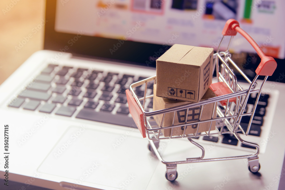 Shopping online. cardboard box with a shopping cart logo in a trolley on laptop keyboard. Shopping service on The online web. offers home delivery
