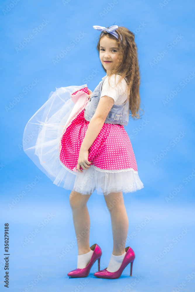 Little girl posing for a photo in pink dress and on high heels. foto de