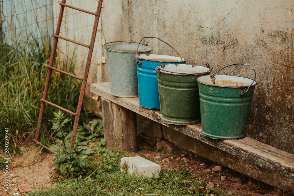 Four old and rusted buckets laying next to each other. Four old and rusted buckets laying next to each other.
