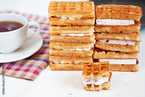 Belgian waffles are stacked on a table.
