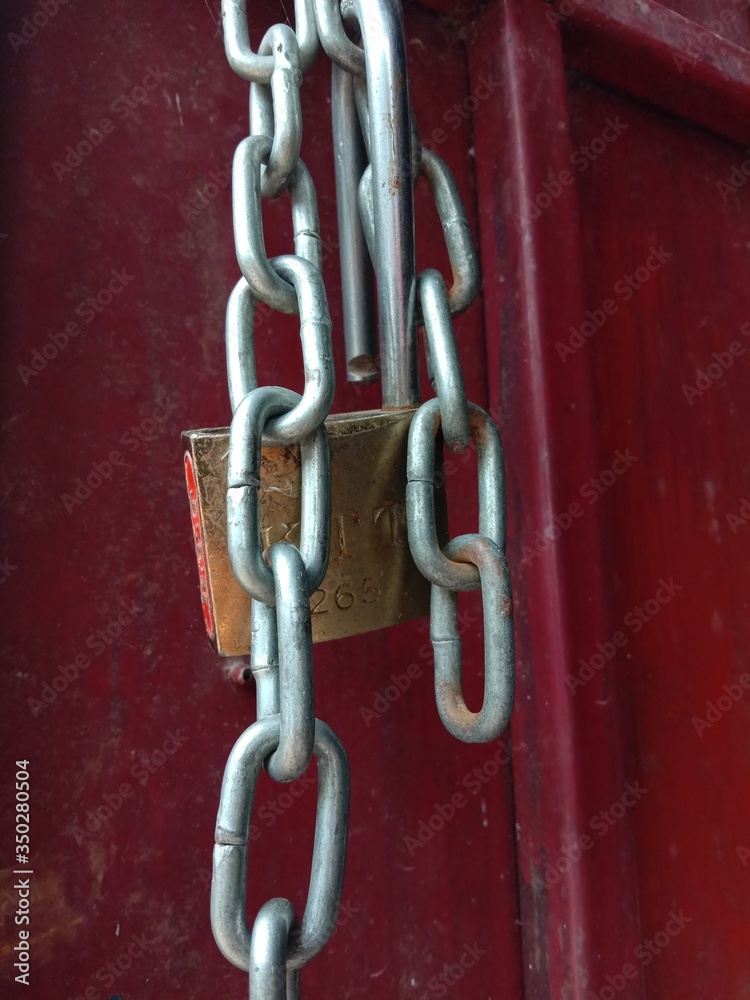 Old padlock chain on the red door Old padlock chain on the red door