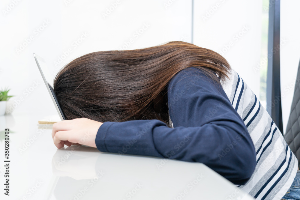 Young woman long hair fall asleep on desk with laptop Young woman long hair fall asleep on desk with laptop