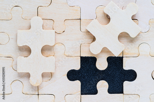 wooden jigsaw puzzle pieces on black background