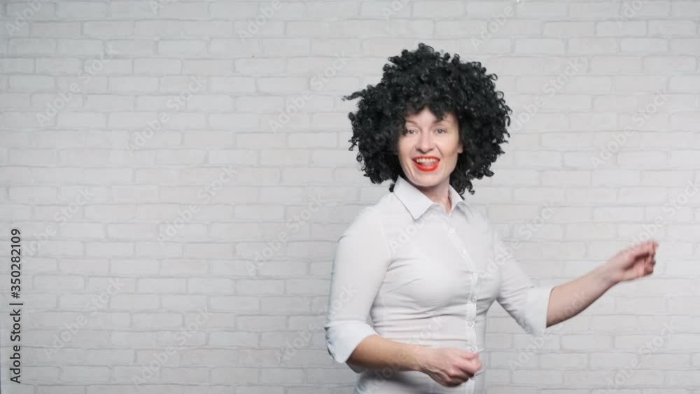 Business woman dancing with smile on face on background of wall. Business woman dancing with smile on face on background of wall.