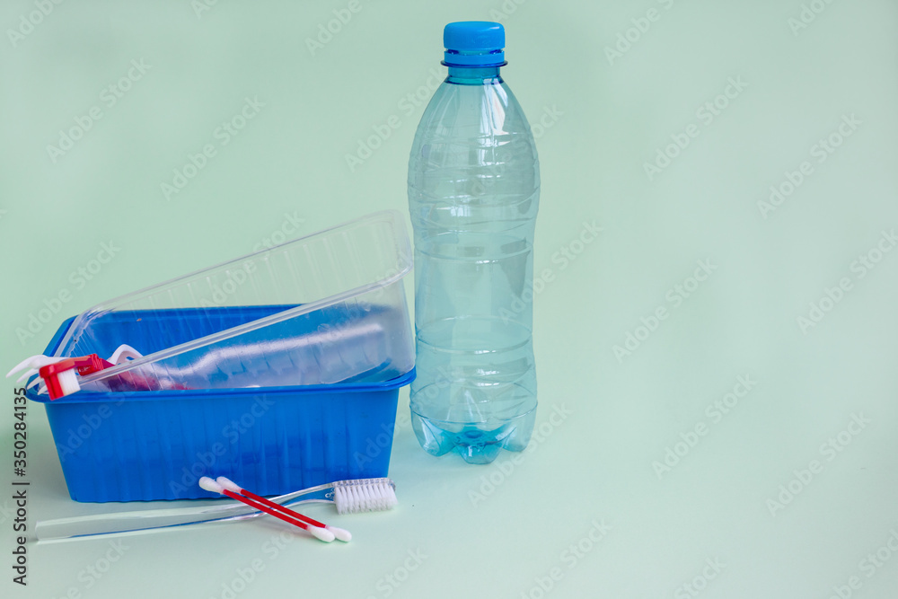 Household plastic waste: several objects on a light green background Household plastic waste: several objects on a light green background