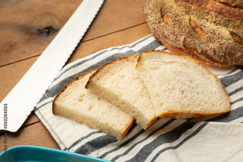 Sliced sourdough bread beside a serrated knife