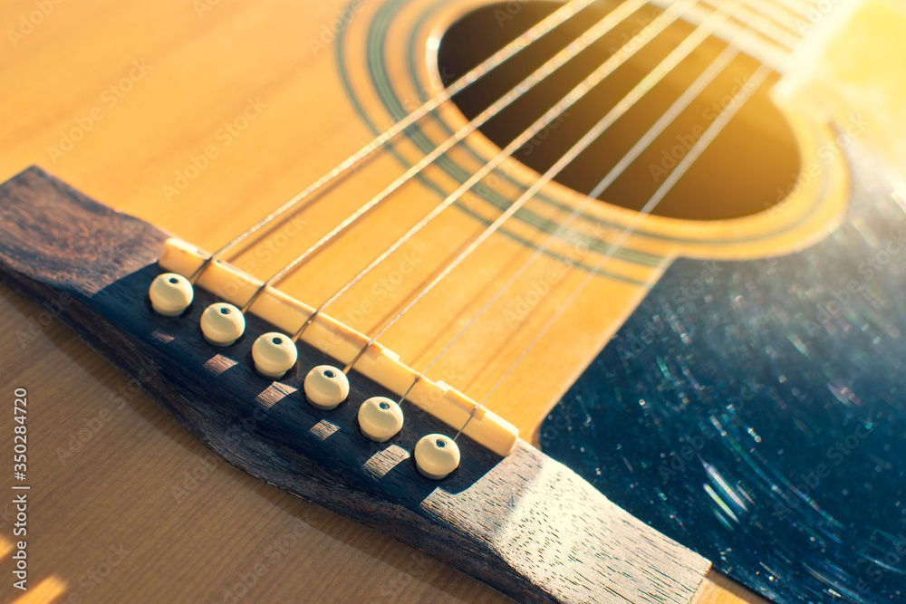 Close up of Guitar acoustic bridge with a sunlight on top. Close up of Guitar acoustic bridge with a sunlight on top.